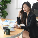 Business professional using cloud phone system on mobile device in modern Dallas Fort Worth office comparing hosted VoIP vs on-premise PBX options