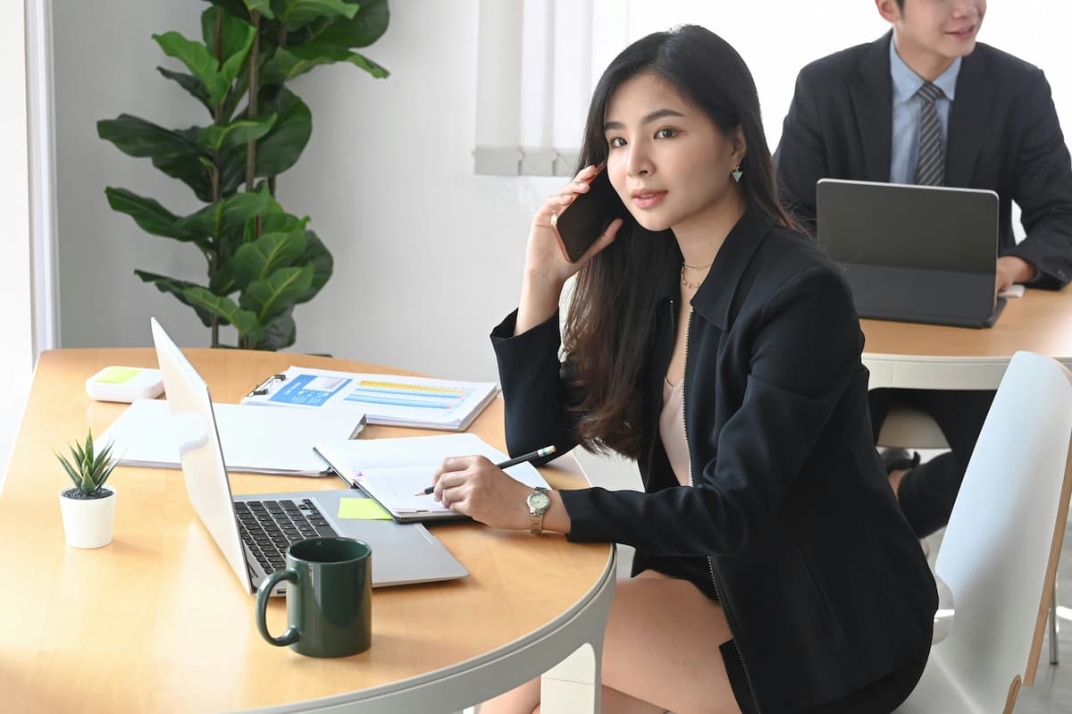 Business professional using cloud phone system on mobile device in modern Dallas Fort Worth office comparing hosted VoIP vs on-premise PBX options