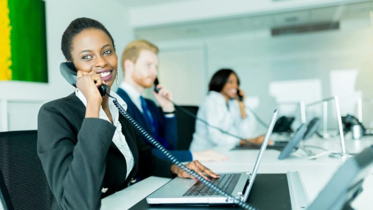 Business office team answering calls using an auto-attendant phone system in Dallas-Fort Worth