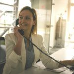 Healthcare front desk professional using a HIPAA-compliant healthcare phone system in a Dallas-Fort Worth medical office