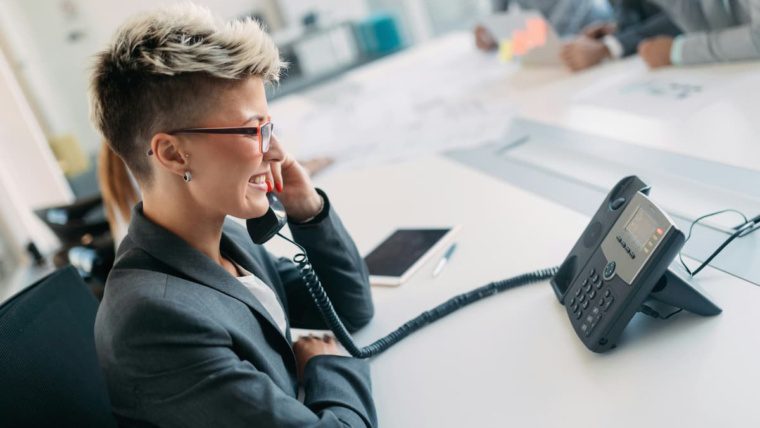 Business professional comparing Intermedia Elevate vs RingCentral cloud phone system in DFW office