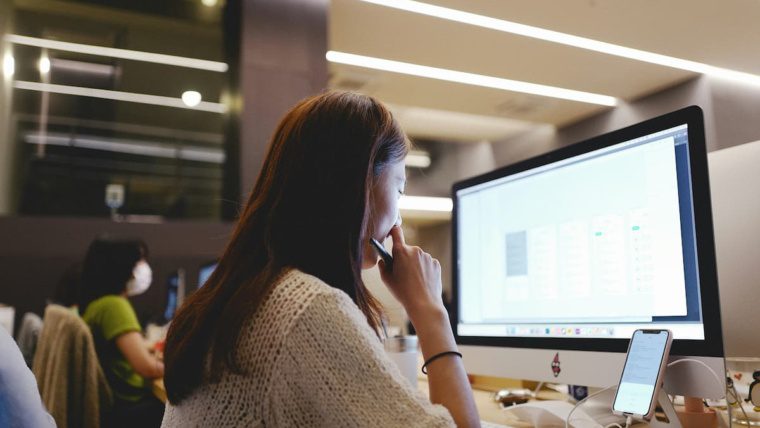 IT professional reviewing VoIP network requirements on computer before deploying cloud phone system