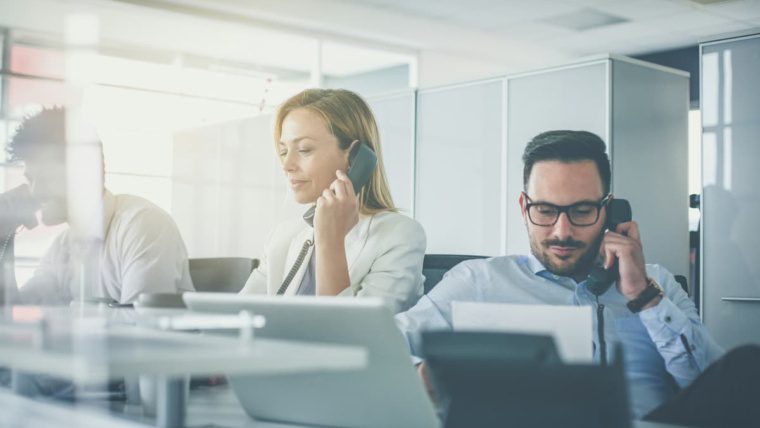 Business team using office desk phones with SIP trunking for business phone connectivity in Dallas-Fort Worth