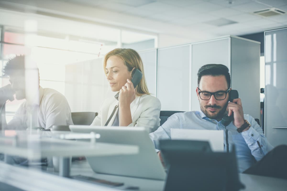 Business team using office desk phones with SIP trunking for business phone connectivity in Dallas-Fort Worth