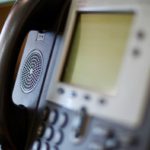 Traditional office phone handset representing the difference between VoIP and landline phone systems for DFW businesses