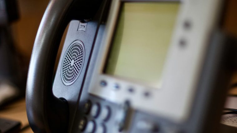 Traditional office phone handset representing the difference between VoIP and landline phone systems for DFW businesses