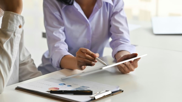 Access control audit Dallas — security professional reviewing access control system findings on a tablet and printed reports, representing the professional audit services NTi Technologies provides for DFW commercial businesses