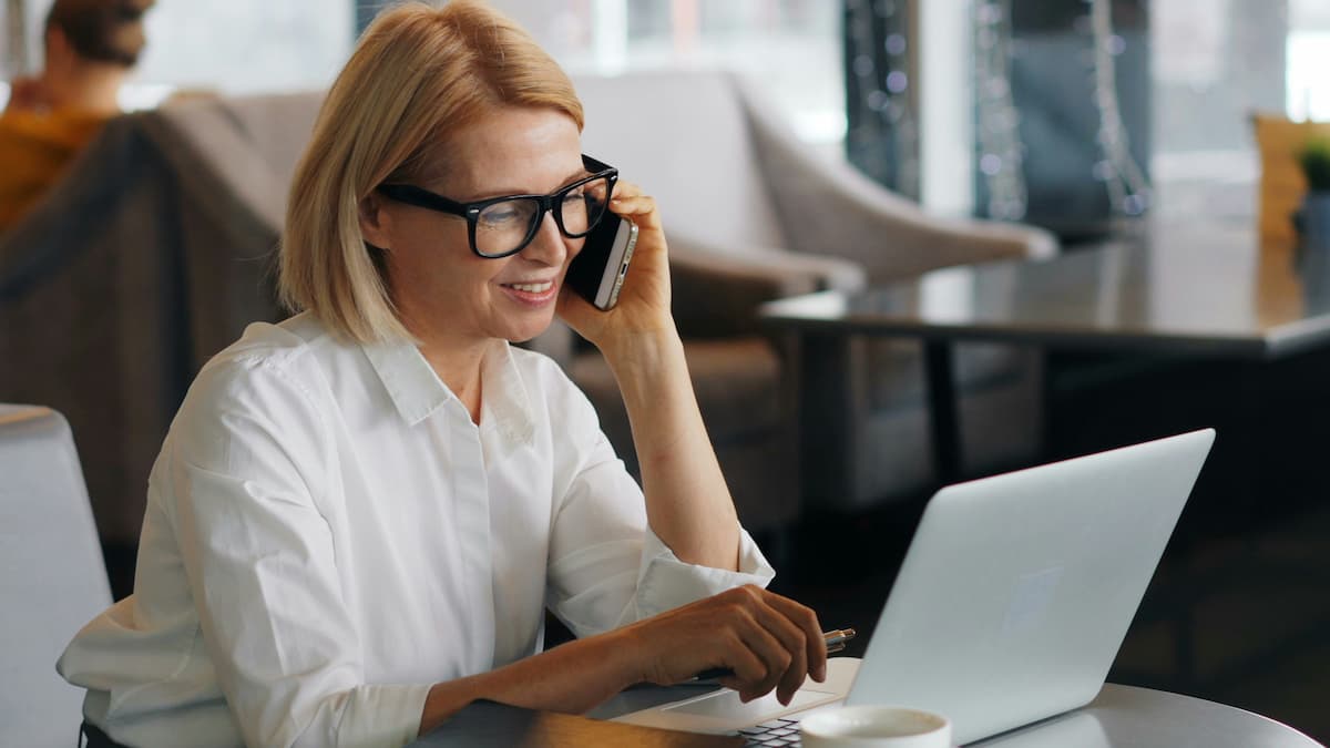 Business professional using AI phone system features on mobile and laptop in Dallas-Fort Worth