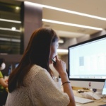 Business professional managing multi-location phone system from central dashboard in Dallas-Fort Worth office