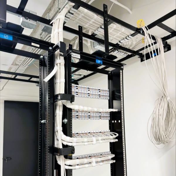 Network rack with bundled cabling routed through overhead trays.