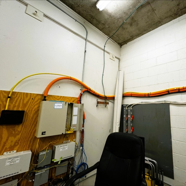 Utility room with fiber and conduit infrastructure along the wall.