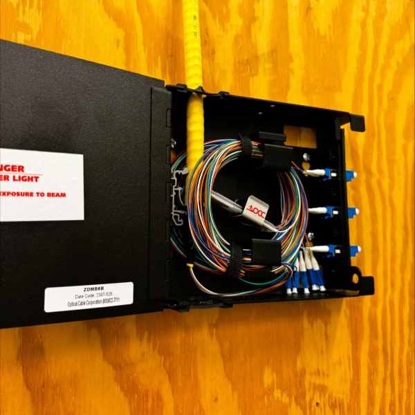 Open fiber enclosure showing organized fiber strands and connectors.
