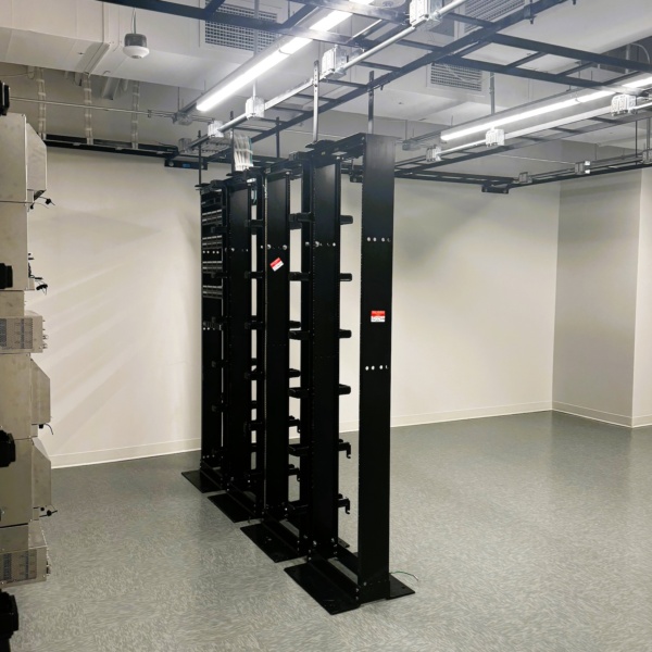 Server room with equipment racks and overhead cable tray system.
