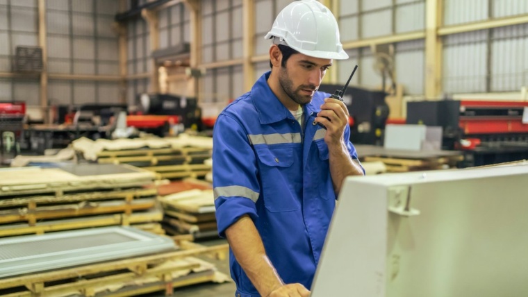 Manufacturing phone system Dallas warehouse worker using a push-to-talk handheld device