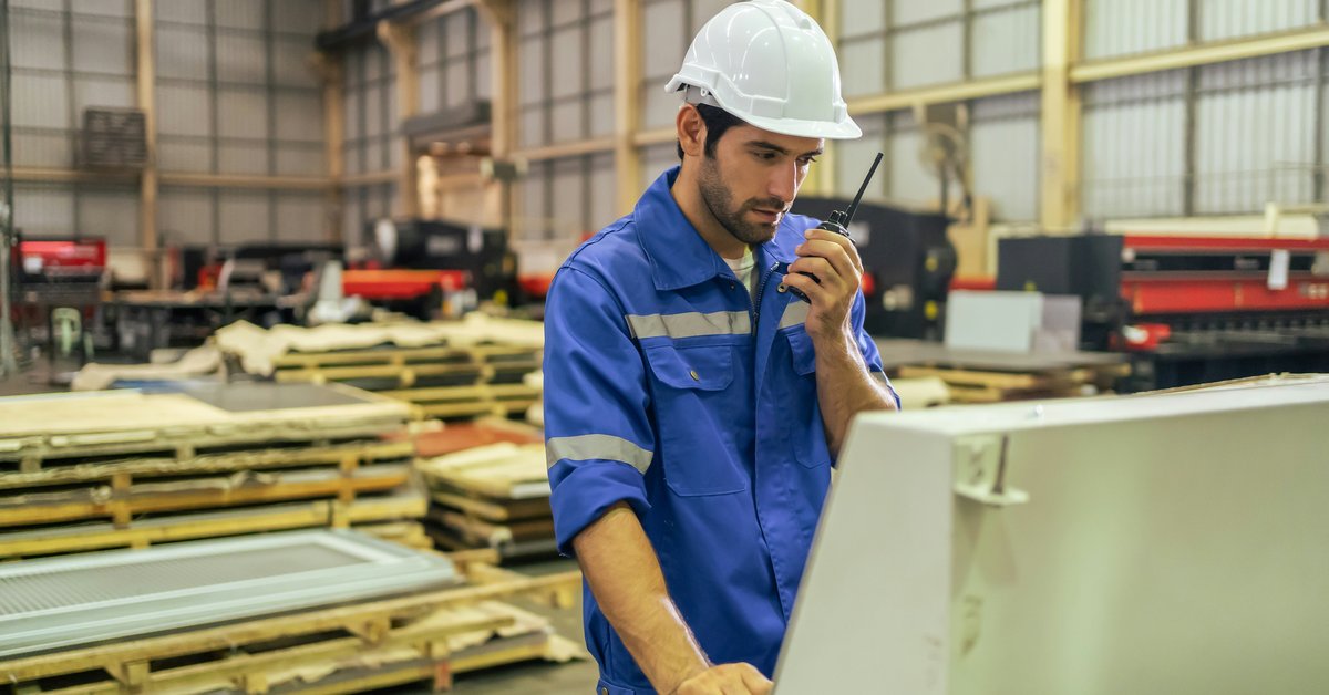 Manufacturing phone system Dallas warehouse worker using a push-to-talk handheld device